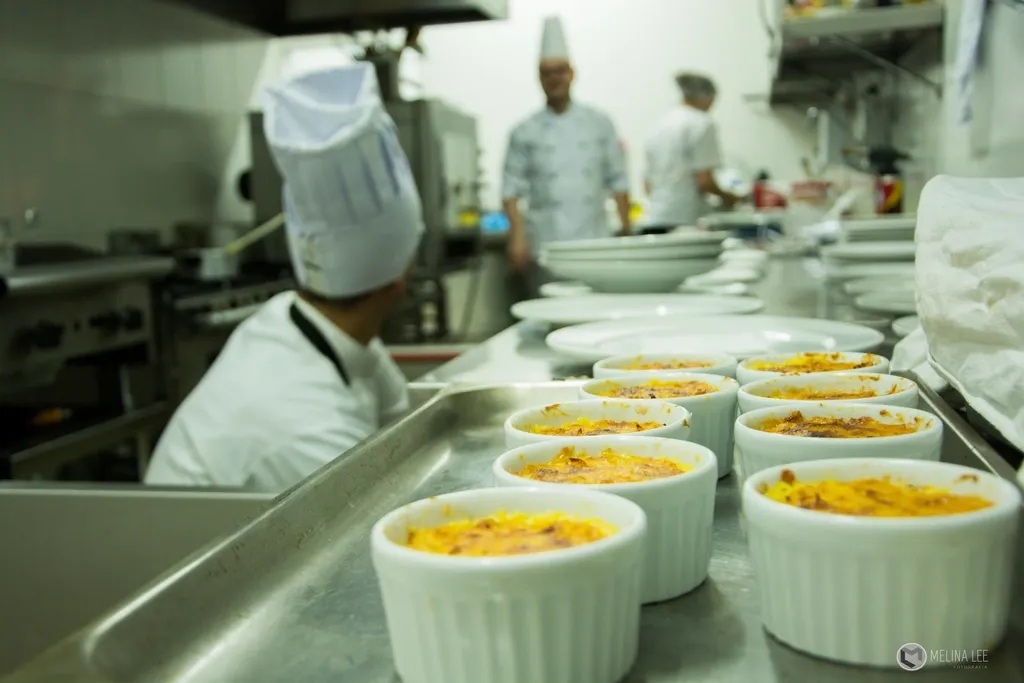 Köche bereiten in einer Restaurantküche Vorspeisen an der Passe vor